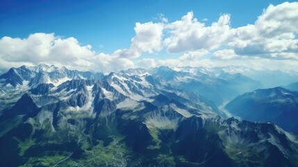Amazing view of snow-capped mountains from above. The peaks of the mountains are covered in snow, while the valleys are green and lush.