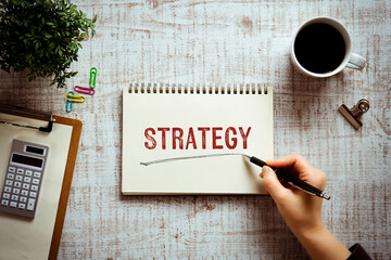 There is notebook with the word Strategy. It is as an eye-catching image.