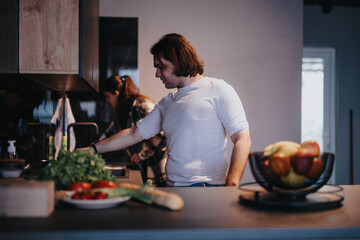 A man and a woman preparing a meal together, sharing a moment of companionship in a cozy kitchen