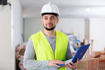 Focused man builder working with laptop on indoor building construction site
