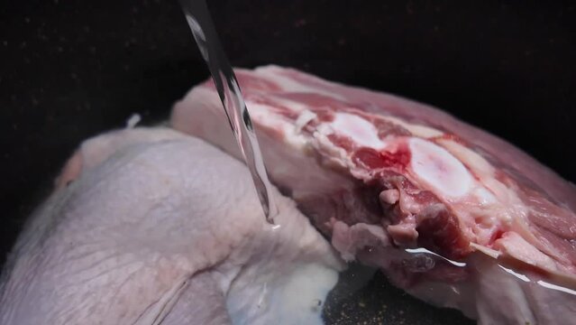 Meat for soup, pork and chicken leg in a pot with water
