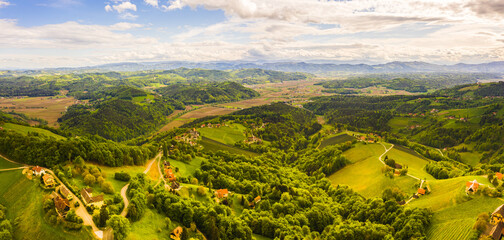 Aerial panorama of of green hills and vineyards with mountains in background