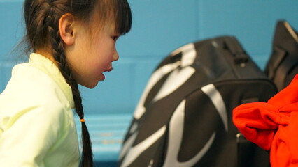 A girl is in the changing room and preparing to play hockey.