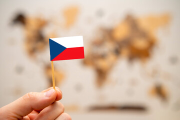Czech Republic flag in mans hand on the world map background.