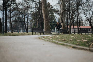 Young woman enjoying a leisurely bicycle ride in a peaceful park setting.