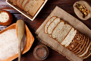whole wheat bread with grains and seeds sliced on wooden table