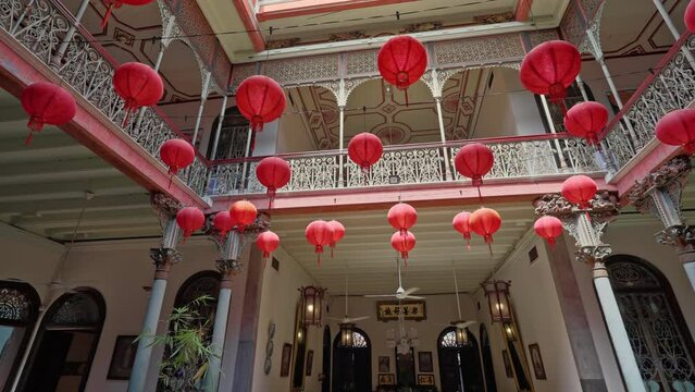 Parallax movement around an old traditional interior Chinese courtyard filled with red lanterns and detailed iron railings