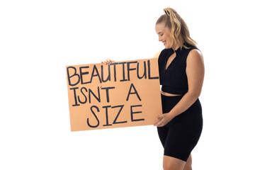 Caucasian young female plus size model holding poster, wearing black outfit on white background - 788839928