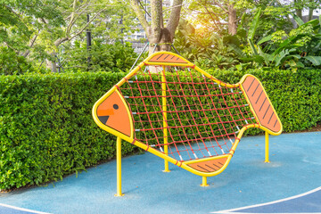 Children's new modern sports playground with rope wall in the open-air courtyard.