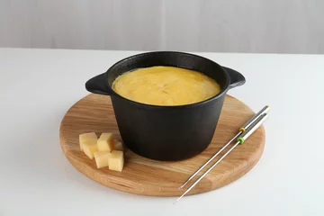 Fotobehang Fondue with tasty melted cheese and forks on white table © New Africa