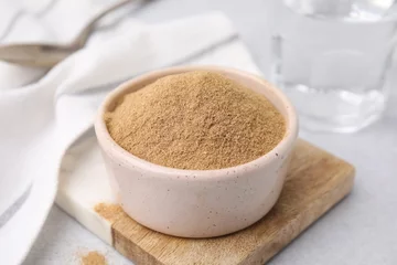 Gordijnen Dietary fiber. Psyllium husk powder in bowl on light grey table, closeup © New Africa