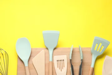 Foto op Plexiglas Different spatulas and tongs on yellow background, flat lay. Space for text © New Africa
