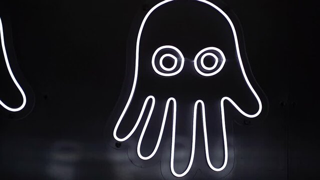 Neon sign of glowing jellyfish that look like hands on a black background. Image of jellyfish.