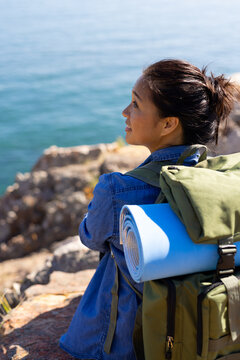 Biracial female hiker looking at sea, copy space