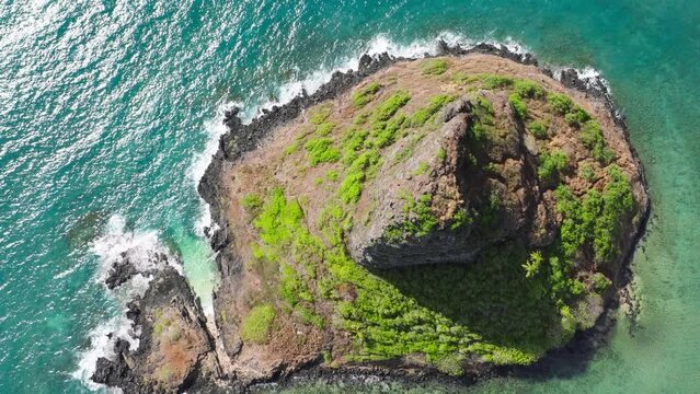 Impressive unique ecosystem and environment on Hawaii island. Famous landmark small island named Chinamans hat. Mokolii volcanic island aerial on sunny summer day. Oahu travel destination aerial 4K