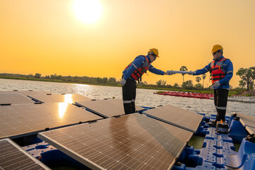 Male workers repair Floating solar panels on water lake. Engineers construct on site Floating solar...