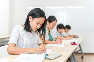 塾・学校・学童で自習・宿題をする小学生・中学生の子供

