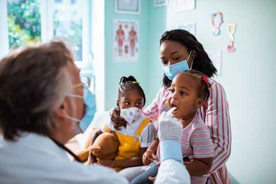 Mother and daughter wearing face masks at pediatrician's appointment