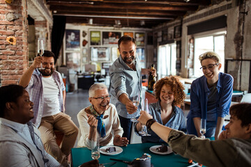 Multigenerational and diverse group of people celebrating a birthday in a startup company office