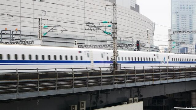 view to bullet high speed train on railway track while moving fast through the city of Tokyo in Japan approaching to the Tokyo Station in winter daytime