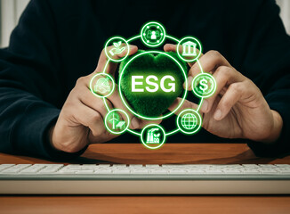 Environmental, social, and corporate governance, environment sustainable for save earth concept. ESG acronym surrounded with ESG element icons with man holding green heart ball on desk in workplace.