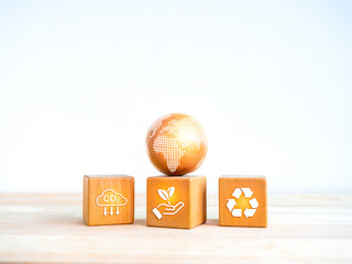Net Zero, limit climate change, global warming, carbon dioxide reduction concept. Earth globe on wood block blocks with reduce CO2 emissions icon, planting tree and recycle symbol on white background.