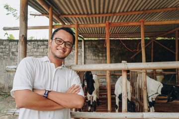 Excited young Asian man standing in front of traditional cage made from wood and bamboo in...