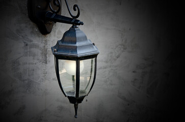 A bright lantern hangs on the stone wall