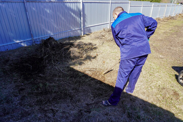 A man works in a vegetable garden in early spring.