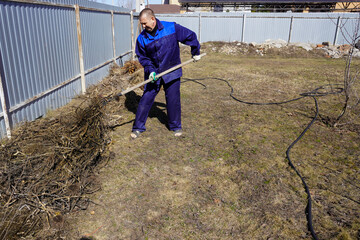 A man works in a vegetable garden in early spring.