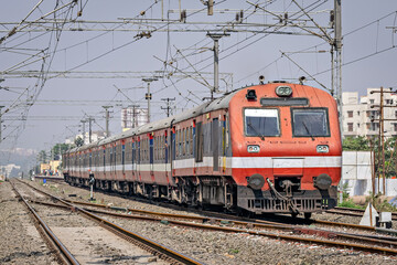 Fototapeta na wymiar Indian Railways Diesel-Electric Multiple Unit local train exiting out of a wayside station near Pune