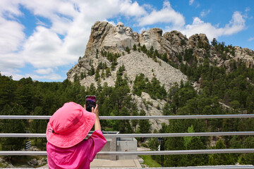 Fototapeta na wymiar A little girl taking photos of Mount Rushmore National Memorial in South Dakota 
