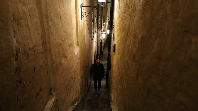 Stockholm, Sweden A man walks in the city's narrowest alley, Marten Trotzigs Grand in Gamla Stan or Old Town at night. 