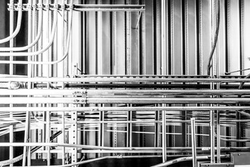 Looking up into an industrial ceiling with complex crisscross of utilities. 