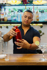 A man is making a drink in a bar