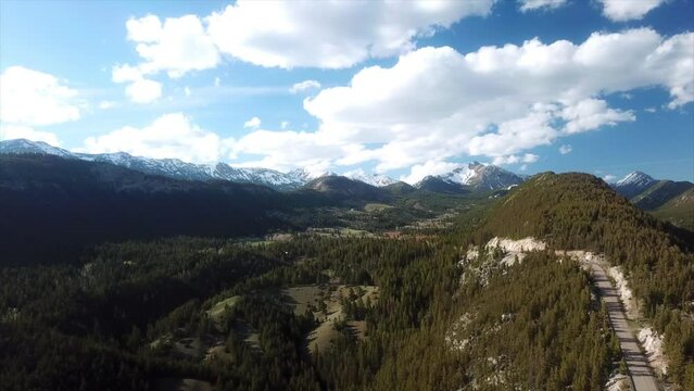 Aerial Beautiful View Of Snowcapped Mountains Under Clouds On Sunny Day - Flathead National Forest, Montana