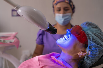 Dentist checking his patient's cavities with a blue light