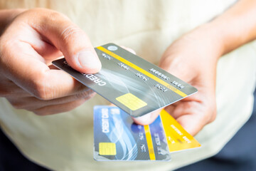 Man holding several credit cards and he is choosing a credit card to pay and spend Payment for goods via credit card. Finance and banking concept	