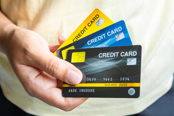 Man holding several credit cards and he is choosing a credit card to pay and spend Payment for goods via credit card. Finance and banking concept	