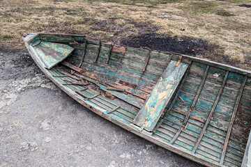 An abandoned boat on the riverbank on a spring day
