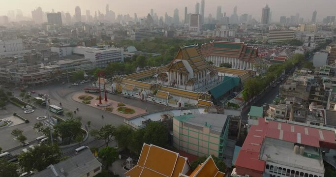 An aerial view of Red Giant Swing and Suthat Thepwararam Temple at sunset scene, The most famous tourist attraction in Bangkok, Thailand.
