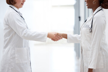 Female doctor and nurse, shaking hands for partnership, agreement and thank you for assistance....