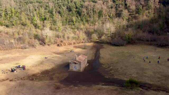 Aerial Drone Fly UP, Revealing Inactive Santa Margarida Volcano: Massive Crater and Historic Chapel in Catalonia Spain. Overgrown Forested Ruins in the Pyrenees Mountain Ranges.