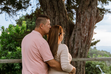 Beautiful adult couple in love talking and looking at their natural surroundings, daydreaming....