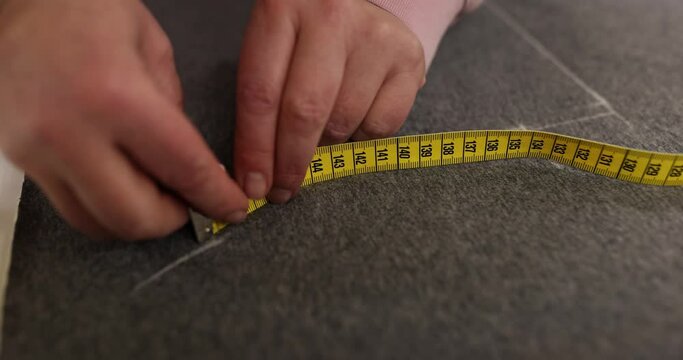 Seamstress uses chalk and measuring tool to mark precise lines