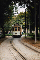Naklejka premium View of a park with the famous retro tourist streetcar in the old town of Porto, Portugal. Traditional Tram