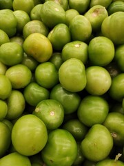 Green tomatoes in a market,Tomates verdes  en un mercado
