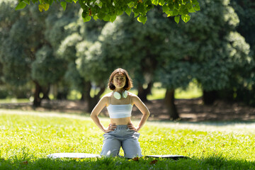 A woman is sitting on the grass in a park