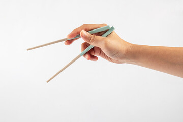 Hand holding chopsticks isolated on a white background