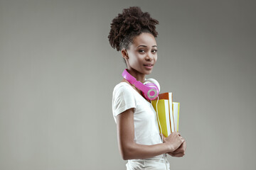 Young woman embraces schoolbooks, looks focused